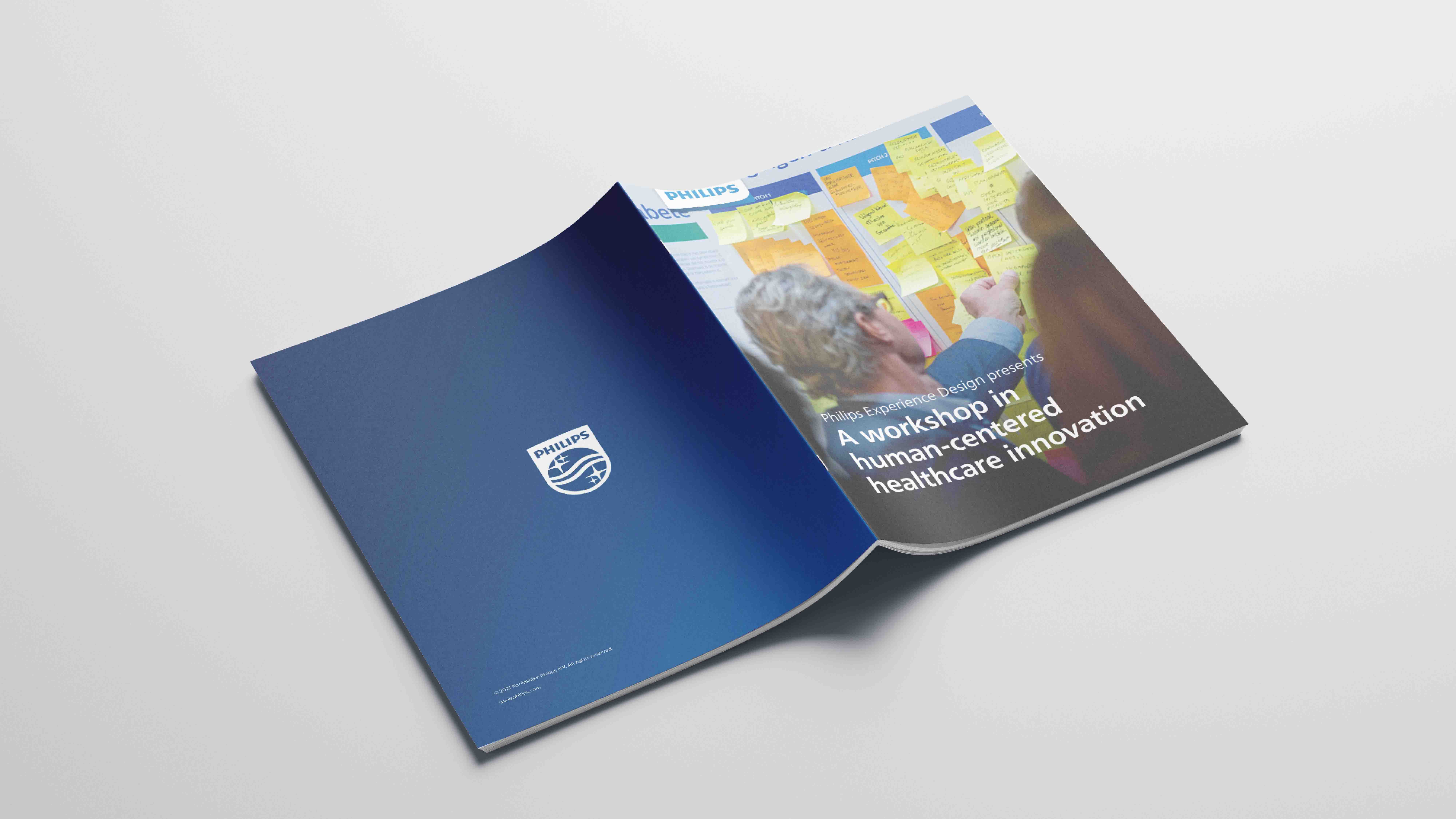 One booklet opened and set face down showing the front and back cover. The cover has typofraphy and a man placing sticky notes on a wall. Booklet was made in Adobe illustrator and Adobe Indesign